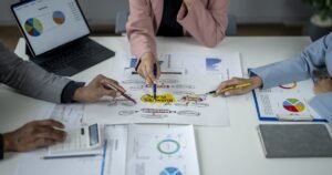 Insights 61 Business team reviewing strategy charts and plans around a table — UK business restructuring