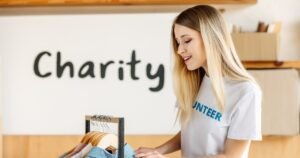 Insights 79 Volunteer sorting donated clothes under a 'Charity' sign in a charity shop — charitable rate relief in the UK