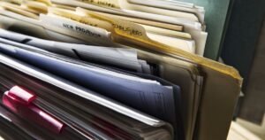 Close-up of business files and labelled folders on an office desk — company filings at Companies House in the UK