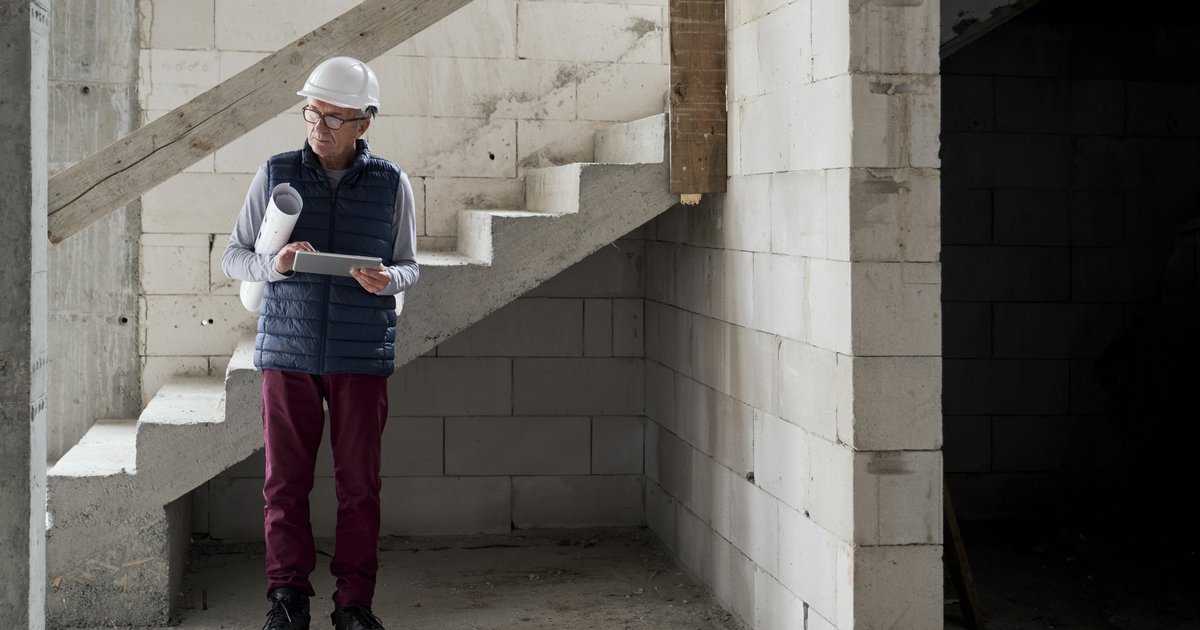 Construction supervisor inspecting an unfinished building interior — defective works claims in UK construction