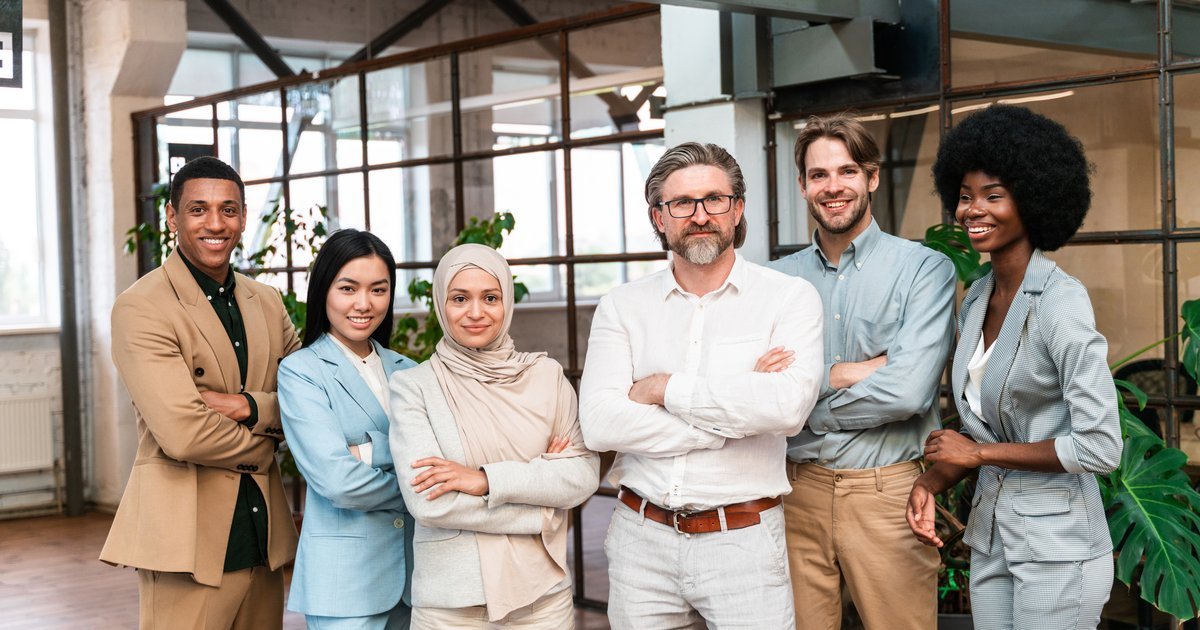 Diverse, inclusive team of professionals standing together in a modern office — UK discrimination claims and workplace equality