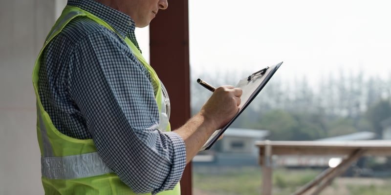 Surveyor inspecting a building and documenting defects