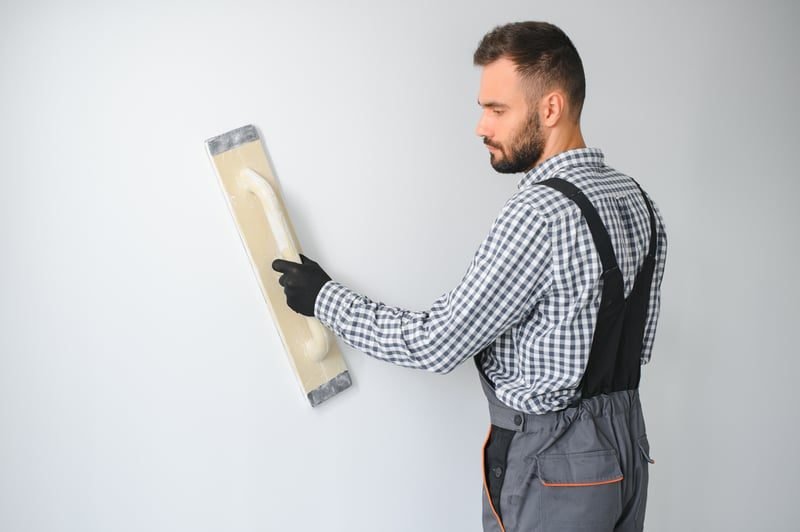 Builder repairing and rectifying defective plasterwork