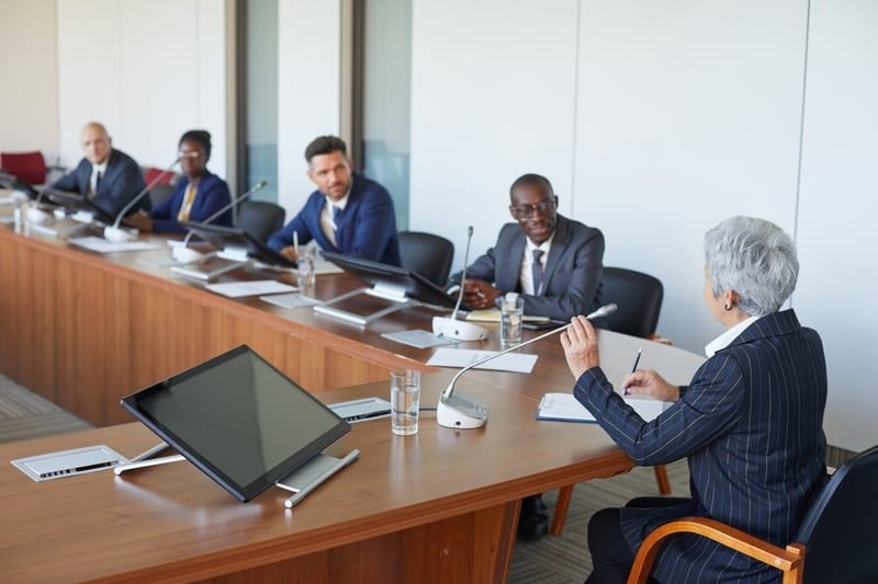 A formal employment tribunal hearing around a table