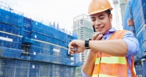 Insights 55 Construction worker in hard hat and hi-vis checking his watch on a UK building site — extension of time claims
