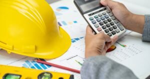 Insights 63 Hand using a calculator over construction cost charts with a hard hat — final account disputes in UK construction