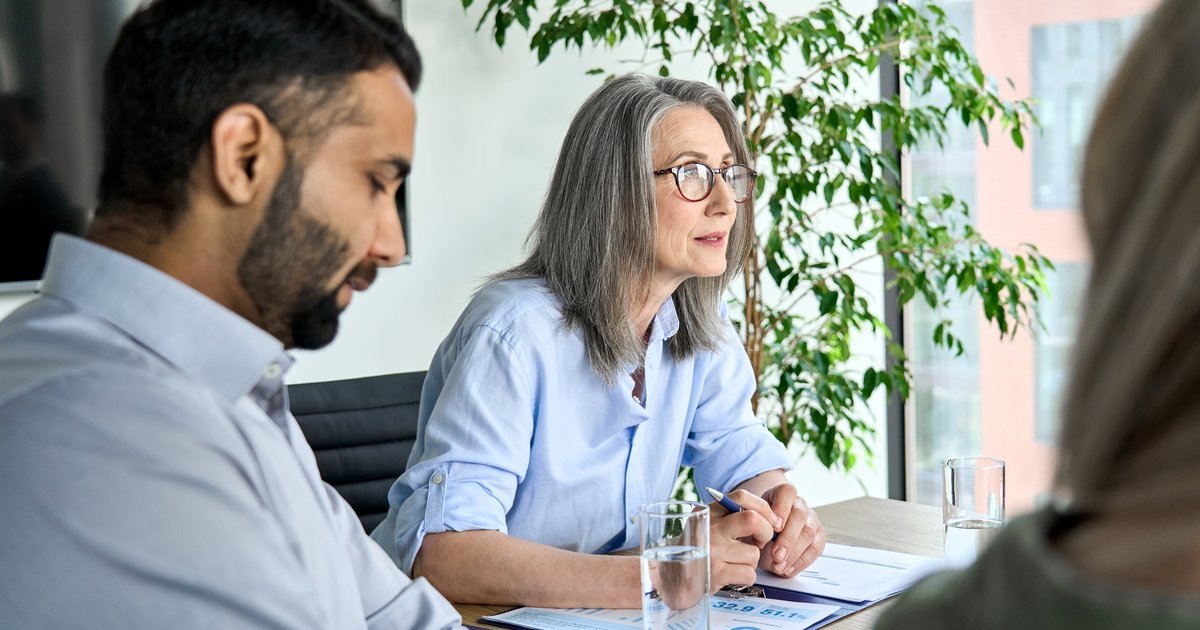 Two HR professionals attentively listening to an employee at a workplace meeting — grievance procedures in the UK