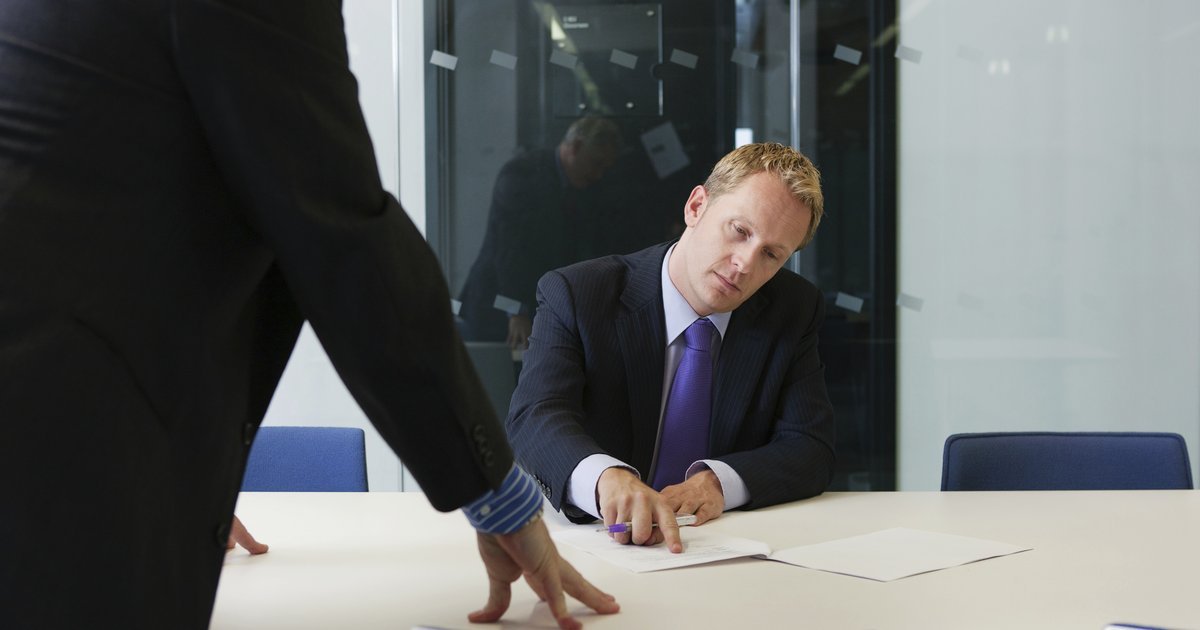 Two professionals reviewing documents in a dispute meeting at a modern office — UK insurance liability disputes