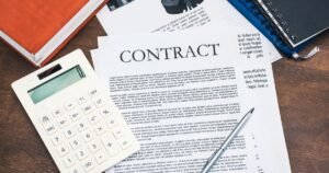 Insights 54 Contract document with a calculator and pen on a desk — calculating liquidated damages under a UK contract