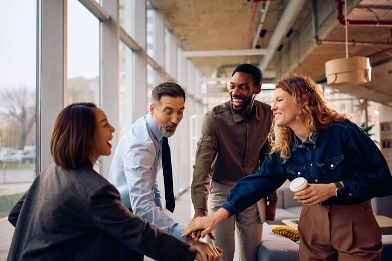 Workplace Mediation: A Complete UK Guide 3 Colleagues shaking hands after resolving a workplace dispute