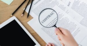 Insights 53 Hand holding a magnifying glass over a contract document on a desk — interpreting insurance policy wording, UK