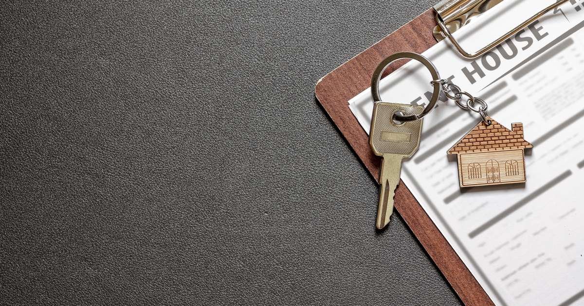 House keys with a house-shaped keychain resting on a rental tenancy agreement, illustrating the UK Renters Rights Act