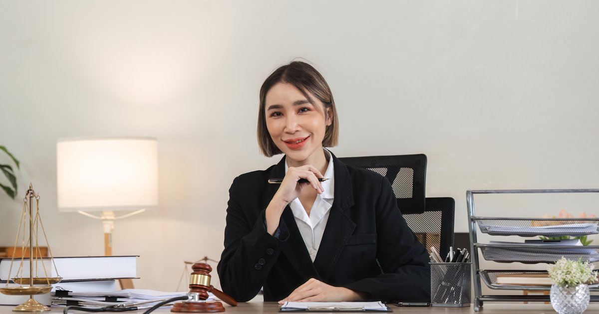 Professional female solicitor reviewing legal documents in a modern office during an unfair dismissal and redundancy case
