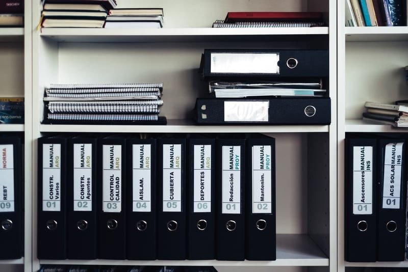 Staff Handbooks: A Complete UK Guide 3 Company policy binders organised on an office shelf
